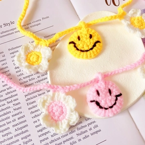Handmade crochet pet collar with yellow smiley face and white flower charms