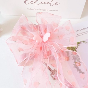 Detail of pink pet harness with organza bow, peach print and rose gold hardware clip