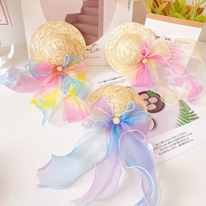 Close-up of handmade mini pet straw hats featuring colorful organza bows and pearls