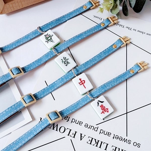 Detail of blue denim pet collar with Mahjong charms and durable yellow plastic buckle