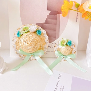 Detailed macro view of handmade woven straw pet hats with lace trim and floral accents