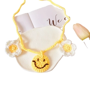 Handmade crochet pet collar with yellow smiley face pendant and small flower accents