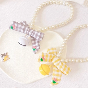 Cat pearl necklace with plaid bow and metal bell shown from a balanced 45-degree angle