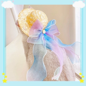 Detail view of woven pet straw hat featuring a large gradient organza bow and metal buckle