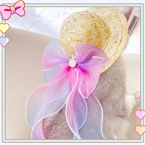 Detail of pet straw hat featuring a large gradient organza bow with a pearl center accent