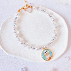 Macro view of cute pet pearl collar with iridescent star beads and cat pendant