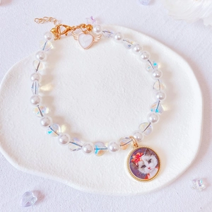 Detail of handmade pet pearl necklace with heart pendant and cat portrait charm
