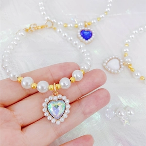 Macro detail of heart sapphire pendants on pearl necklaces for cats and small dogs