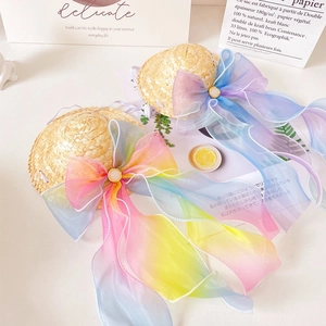 Detail of pet straw hat with large rainbow organza bow and pearl buckle with elastic strap