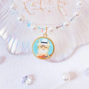 Detailed close-up of handmade pet pearl necklace with star beads and cute cat guitar pendant
