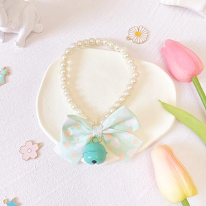 Close-up of pearl pet collar with light green polka dot bow and mint green bell detail