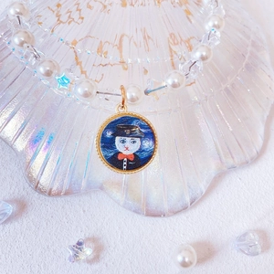 Detailed macro view of handmade pearl pet collar with star beads and cat pendant
