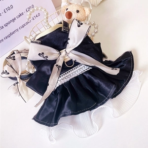 Detail of elegant black satin pet dress with white bow and lace trim for cats and small dogs