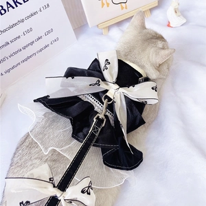 Close-up of elegant black pet harness dress with lace bow and matching leash set