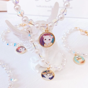 Detail showing handmade cat pearl necklace with heart beads and kitten pendant charm