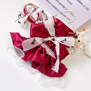 Detail of red satin pet dress with lace edges and matching leash set for cats and dogs