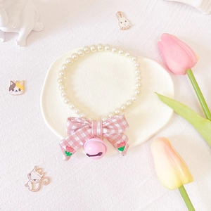 Detail of pet pearl necklace with pink plaid bow and tulip embroidery plus metal bell