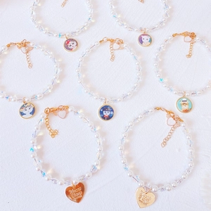 Detailed close-up of handmade pet pearl necklaces with colorful cat charms and gold clasps