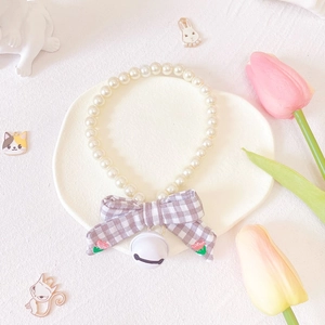 Detail of white faux pearl pet collar with grey plaid bowknot and embroidered red flower