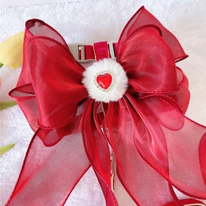 Elegant red bow pet harness with faux fur heart jewel on white plush background