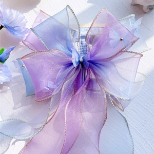 Detail of blue and purple organza butterfly bow harness with pearl accents