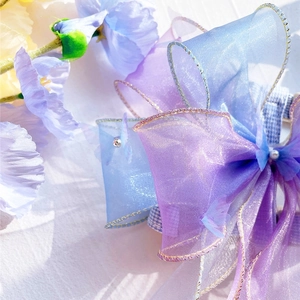 Detail of colorful organza pet harness with large bow, gold edging and pearl accent
