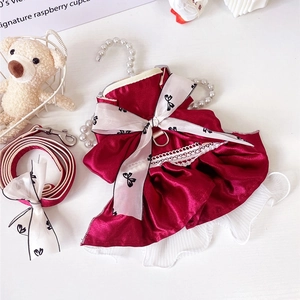 Detailed view of red satin pet dress with large bow, white lace trim and matching leash