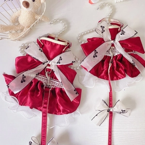 Detail of red satin pet dress with white bow, organza skirt, and pearl leash set
