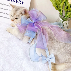 Detail of pet harness featuring a large purple and blue gradient organza bow on a cat
