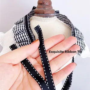 Close-up of black and white checkered pet collar with exquisite ribbon strap detail