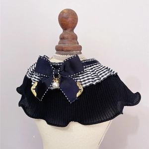 Detail of pet lace bib featuring black bow, checkered trim and pearl pendant charm