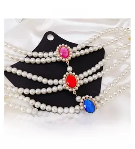 Dettaglio della lussuosa collana di perle per animali con gemme rosse e blu brillanti