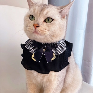 Close-up of black pleated pet collar with checkered frills and golden bow tie detail