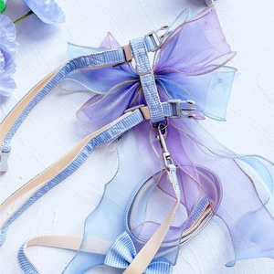 Detail of blue plaid pet harness featuring a large purple gradient organza butterfly bow