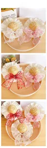Detail of pet straw sun hat with cherry bow and ruffled lace edge for dogs and cats