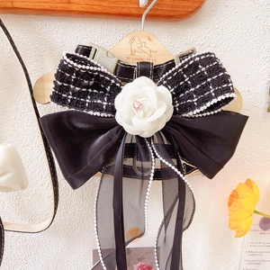 Detail of tweed dog harness with white camellia flower and pearl organza ribbon