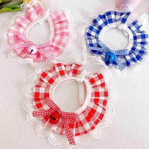Close-up of pet lace collars in pink, blue, and red plaid with bows and metal bells