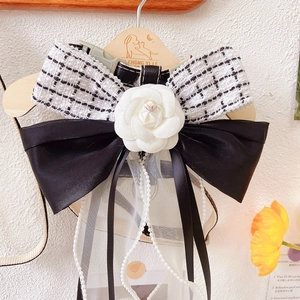 Detail of tweed bow dog harness featuring a white camellia flower and pearl chains