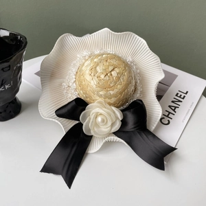 Elegant straw hat pet accessory with lace trim, black bow, and white camellia flower