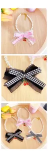 Detail of adjustable pet pearl collar with lace plaid bow and cherry charm