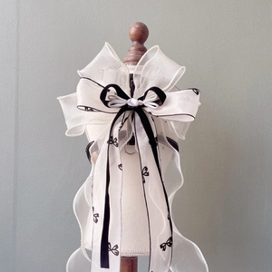 Detail of dog harness featuring white organza lace with a black velvet bow and pearl accent