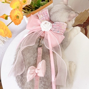 Close-up of pink tweed pet harness with white camellia flower and organza bow detail
