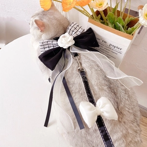 Detail of camellia flower and lace bow on tweed dog harness with pearl edge trim