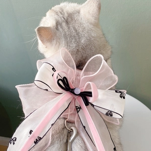 Detail of pink organza layered bow dog harness with metal D-ring on a grey shorthair cat