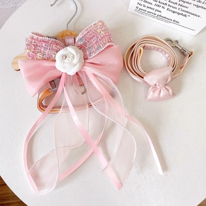 Detailed view of pink tweed dog harness set with large organza bow and camellia flower