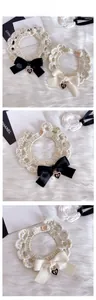 Détail du collier tricoté pour animaux avec fil doré, nœud satin et cœur métal