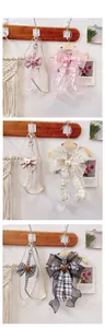 Three color options of bear lace pet harness sets with ribbons on wooden wall hooks