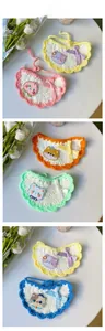 Vue détaillée du bavoir pour animaux au crochet avec bordures fleuries et broderie mignonne