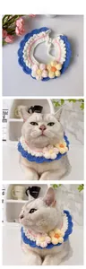 Detail showing handmade knit pet collar with blue ruffles and 3D crochet flowers for cats