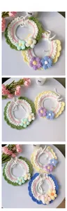Detail view of handmade crochet pet collar with colorful knit flowers and wavy edge